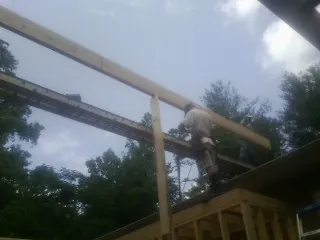 Carpenter setting a ridge beam over a new addition frame — Ice Dam Removal by Roofing Brothers in Union Grove